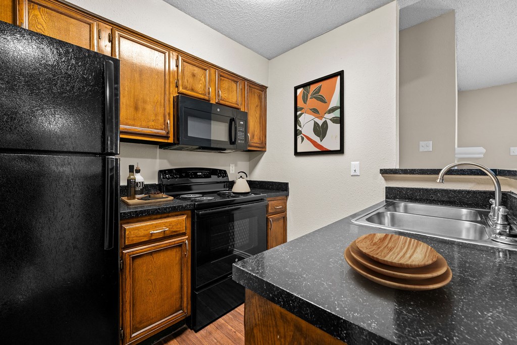 a kitchen with wooden cabinets and black appliances