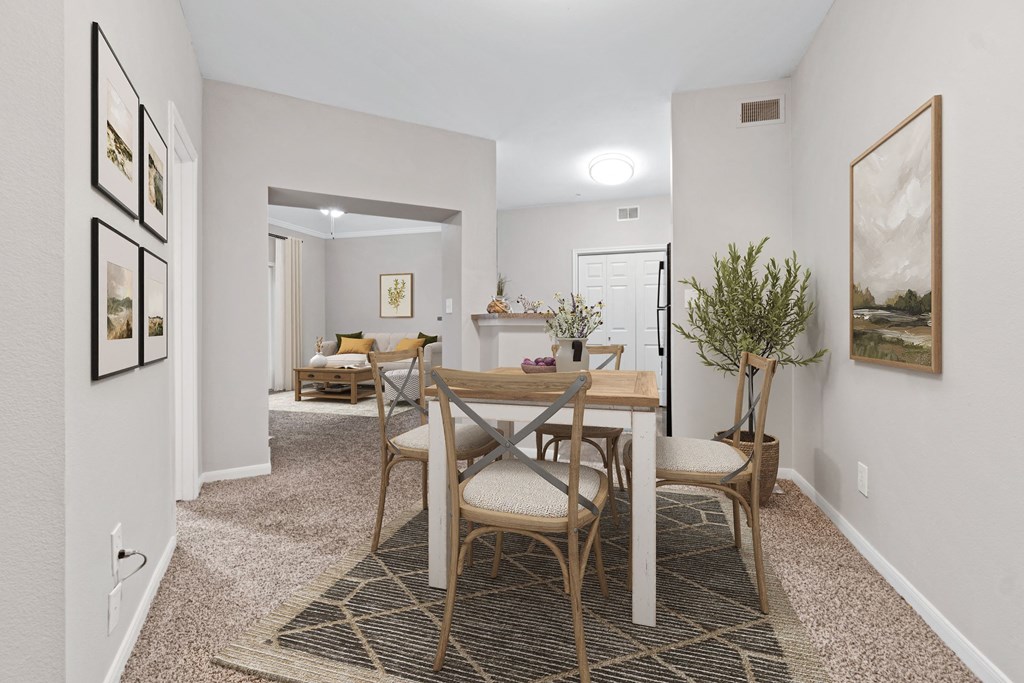 a dining room with a wooden table and chairs at Fountains of Denton in Denton, TX