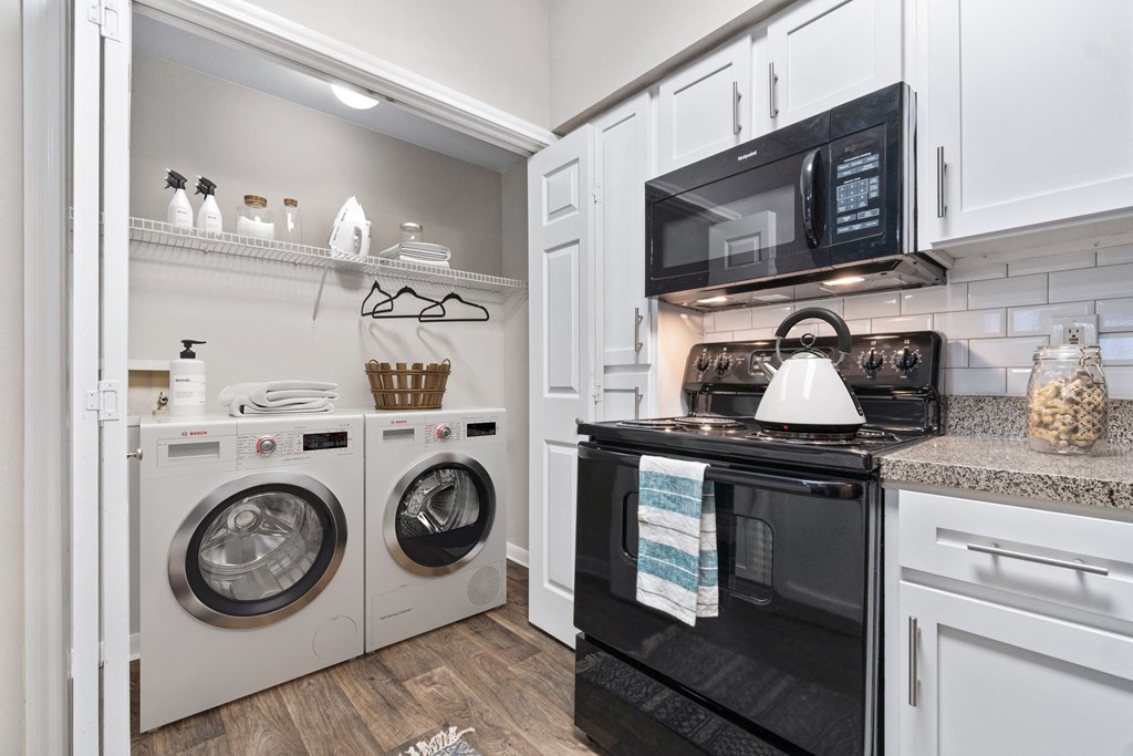 a laundry room with a washer and dryer and a white washer at Fountains of Denton in Denton, TX