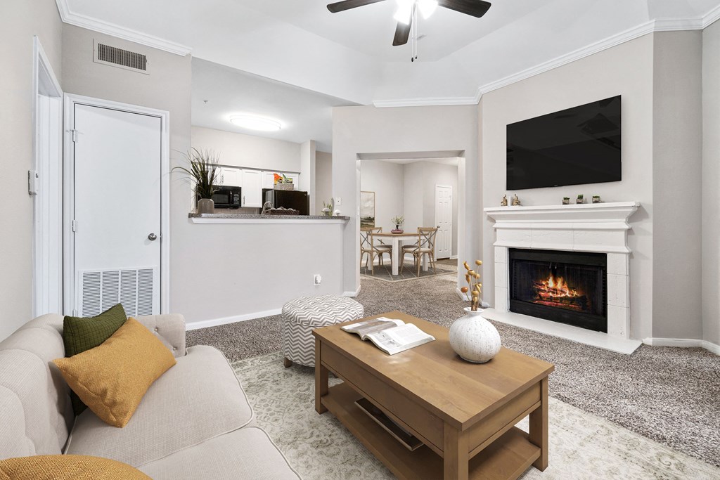 a living room with a fireplace and a couch at Fountains of Denton in Denton, TX