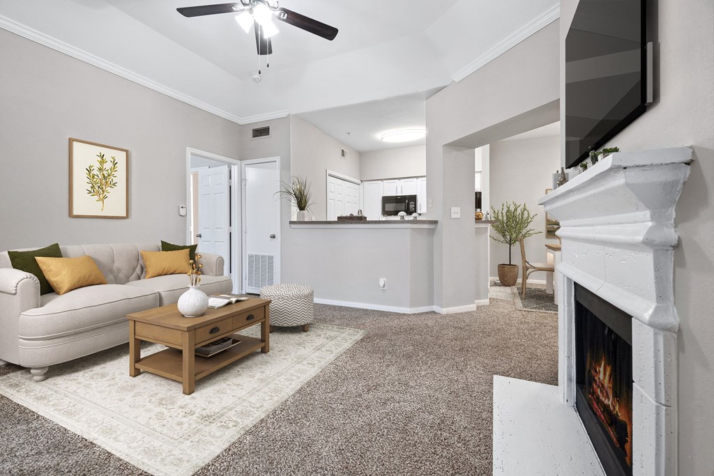 a living room with a fireplace and a couch at Fountains of Denton in Denton, TX