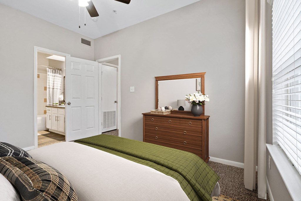 a bedroom with a bed and a dresser with a mirror