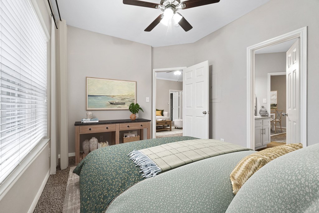 a bedroom with a large bed and a ceiling fan at Fountains of Denton in Denton, TX