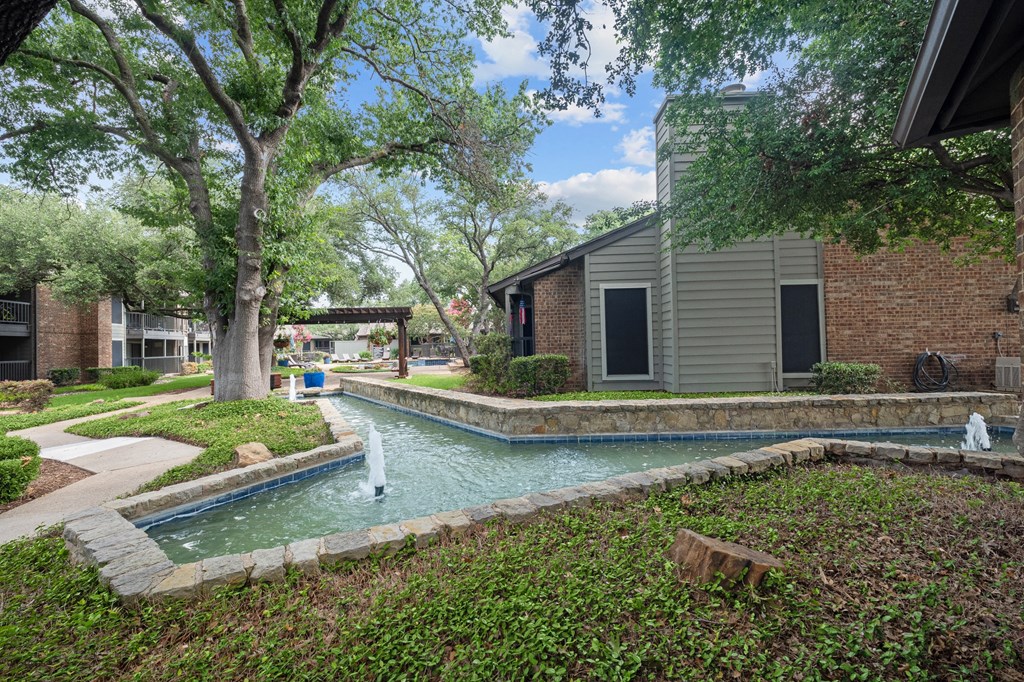 a swimming pool with a fountain in front of a building