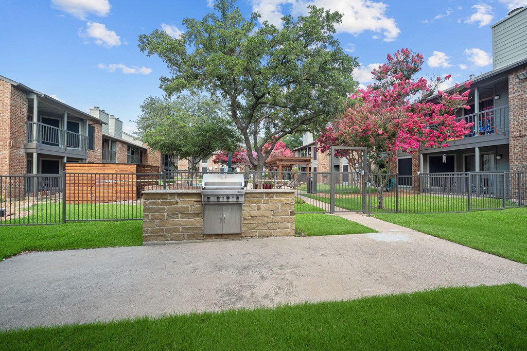 an outdoor barbecue area at legacy apartments in plano, tx