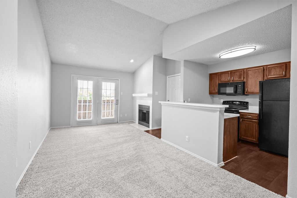 A spacious living room with a kitchenette and a fireplace. at Preston Bend, Dallas, TX, 75252