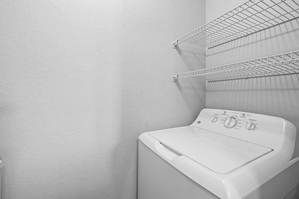 A white washing machine sits in a laundry room. at Preston Bend, Texas