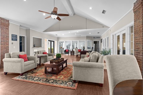 A living room with a rug and a ceiling fan.