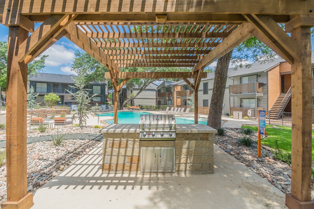 a patio with a grill and a swimming pool