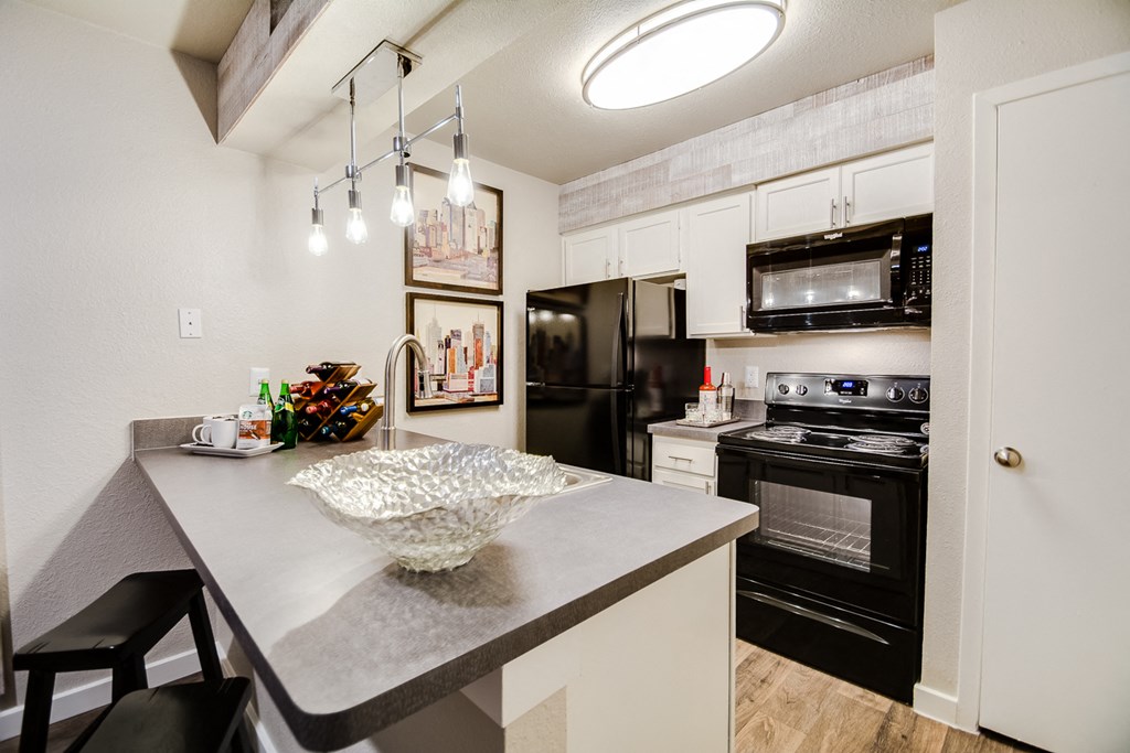 a kitchen with black appliances and a quartz counter top