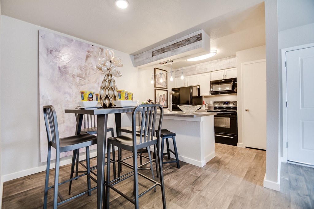 an open kitchen and dining area with a bar and stools