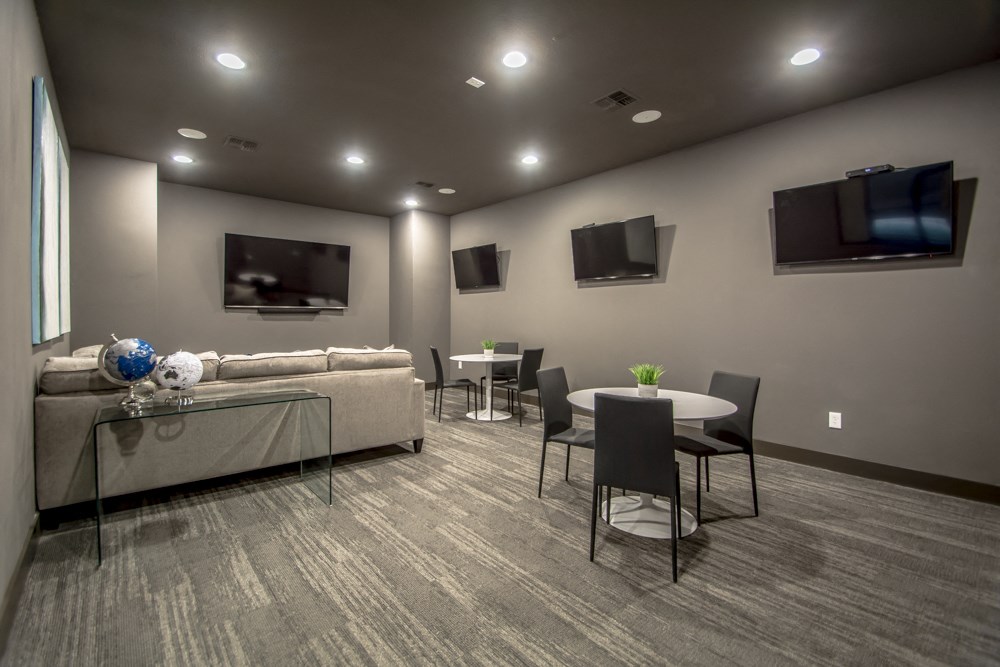 room with couches and a table with chairs and a television on the wall