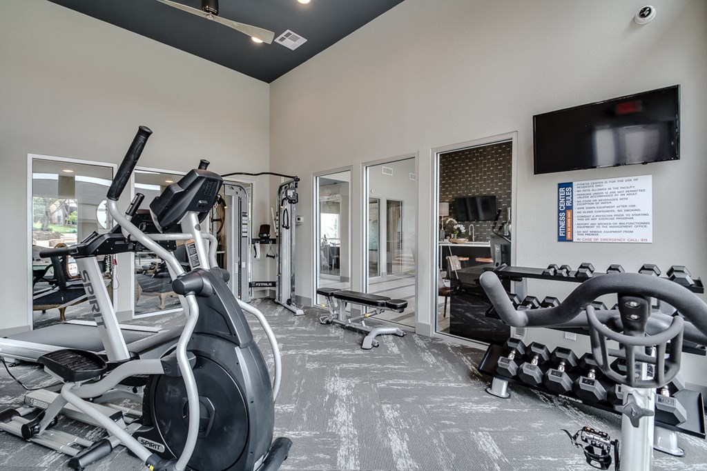 a gym with exercise equipment and a tv