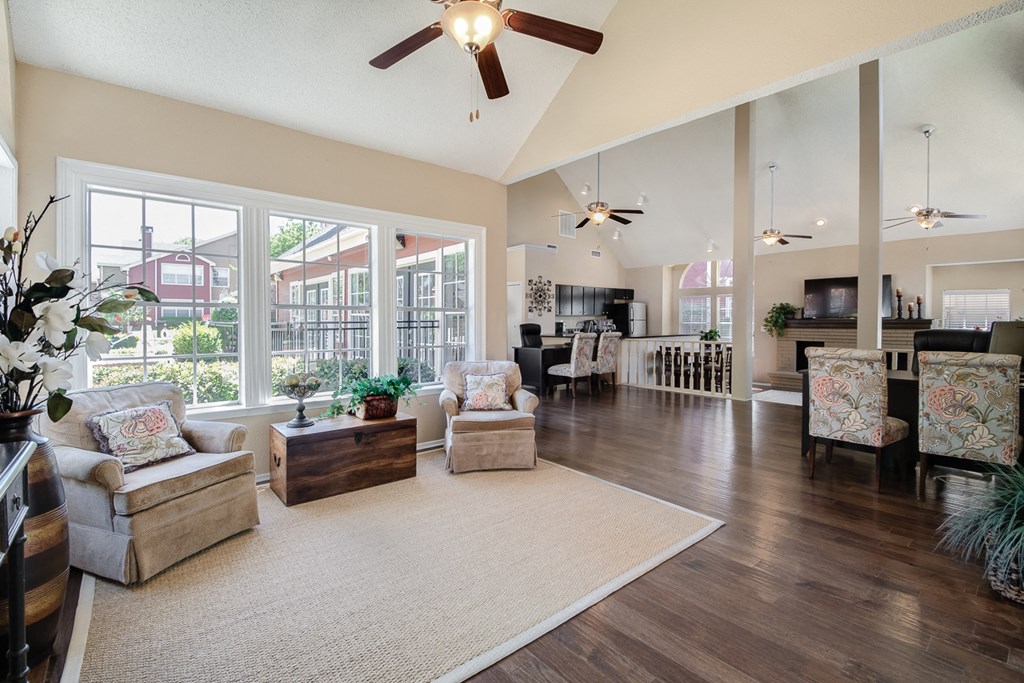 a spacious living room with a ceiling fan and large windows