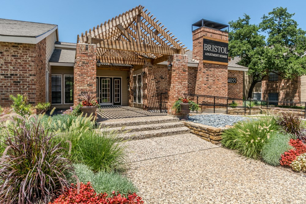 the front of a brick building with a porch and a sign that reads