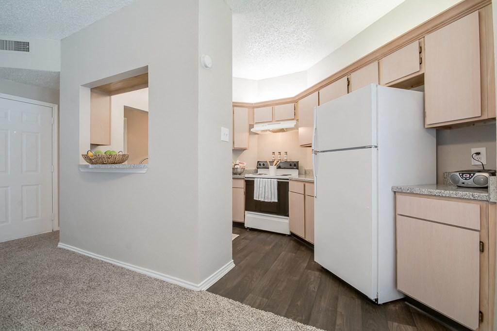 a spacious kitchen with white appliances and wooden cabinets