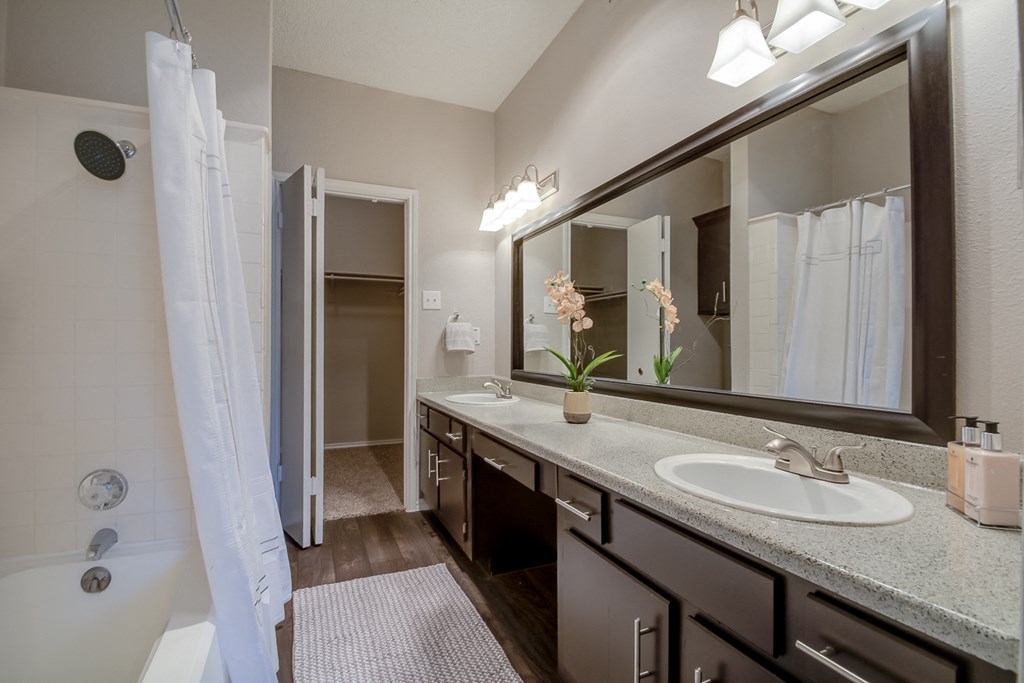 A bathroom with a white sink and a large mirror.