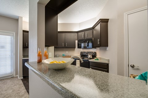 redesigned kitchen with granite countertops and black cabinets and stainless steel appliances