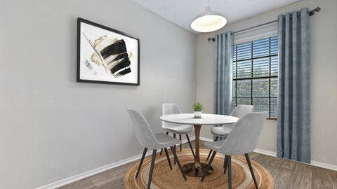 A dining room with a white table and grey chairs.