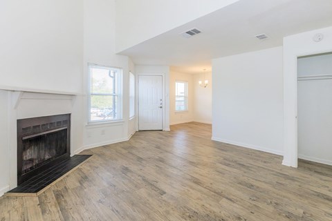 A room with a fireplace and wood flooring.
