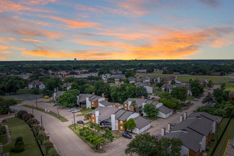 A sunset view of a residential neighborhood with houses and streets.