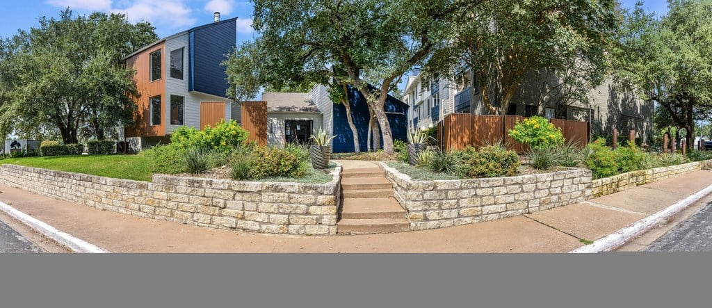 a retaining wall with stairs in front of a house at Peaks at Northwest Hills Apartments, Austin, TX
