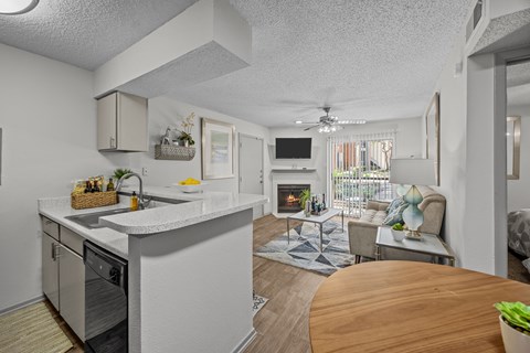 A modern kitchen with a dining table and a living room area.
