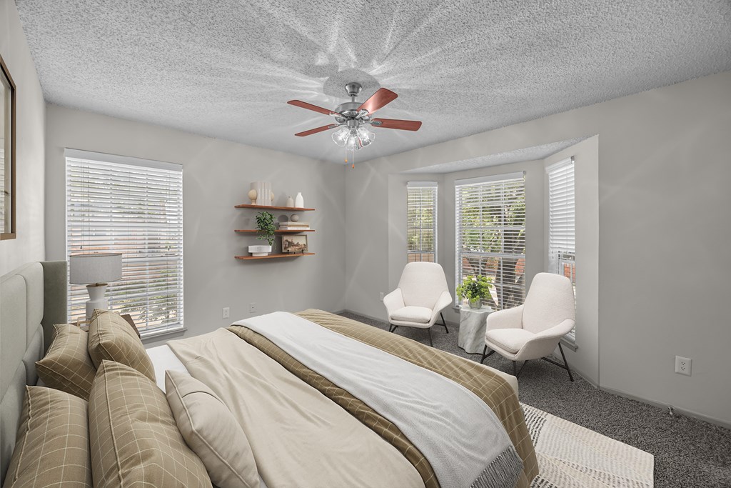 A bedroom with a large bed and a ceiling fan.