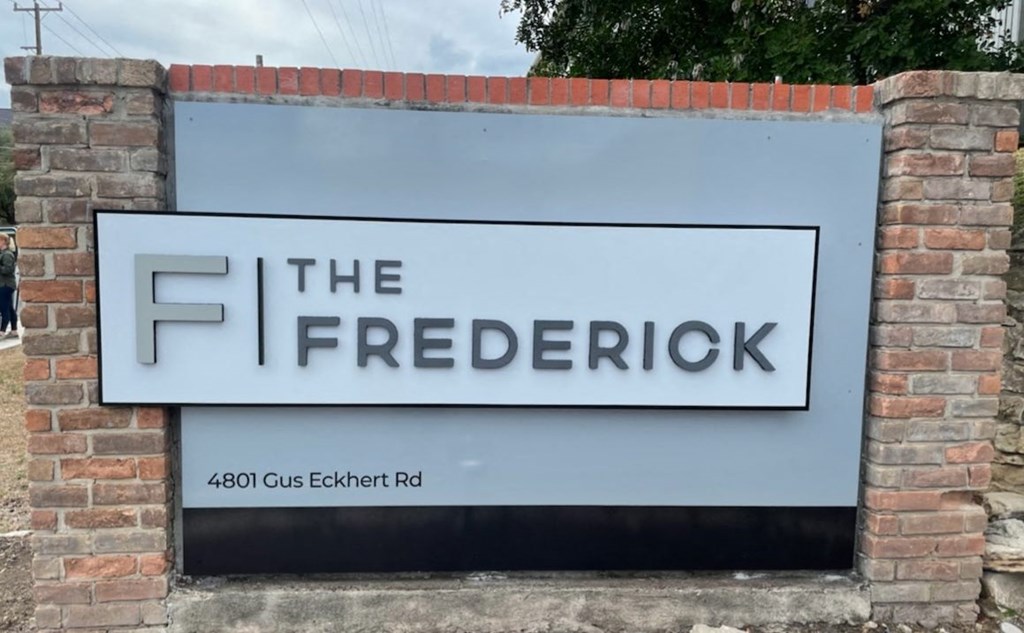 a sign for the frederick sign in front of a brick wall at The Frederick, San Antonio
