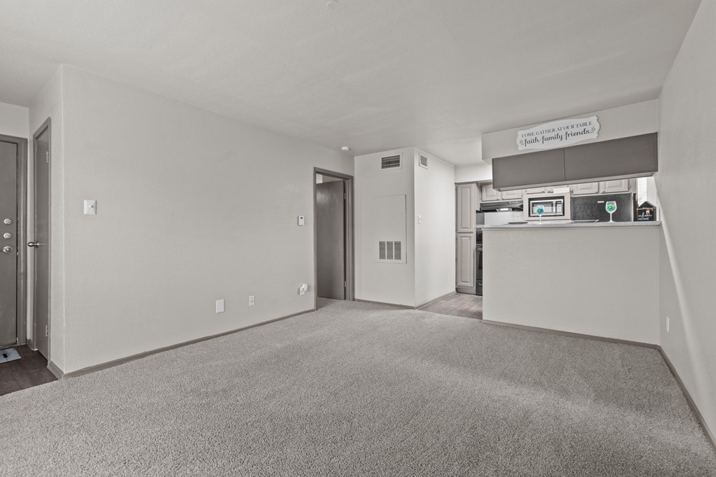 A carpeted room with a white wall and a door.at Rock 35, Round Rock