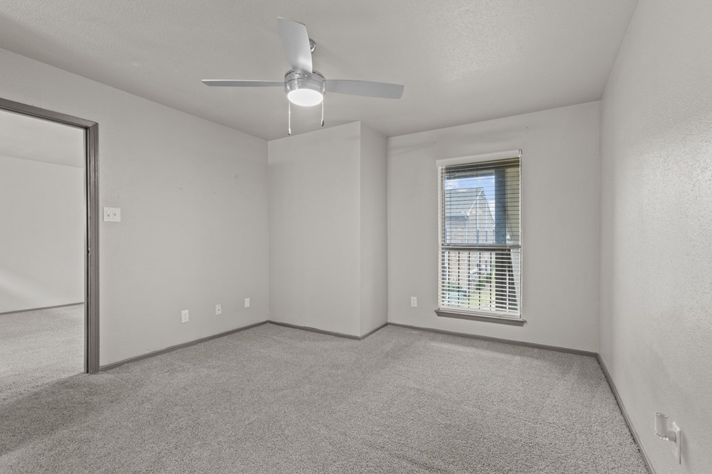 A room with a ceiling fan and a window with blinds.at Rock 35, Round Rock, TX, 78681