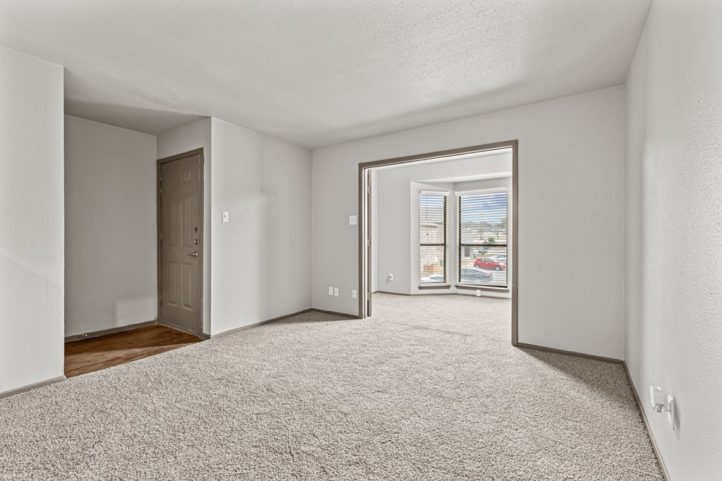 A white room with a carpeted floor and a door on the left side.at Rock 35, Texas, 78681