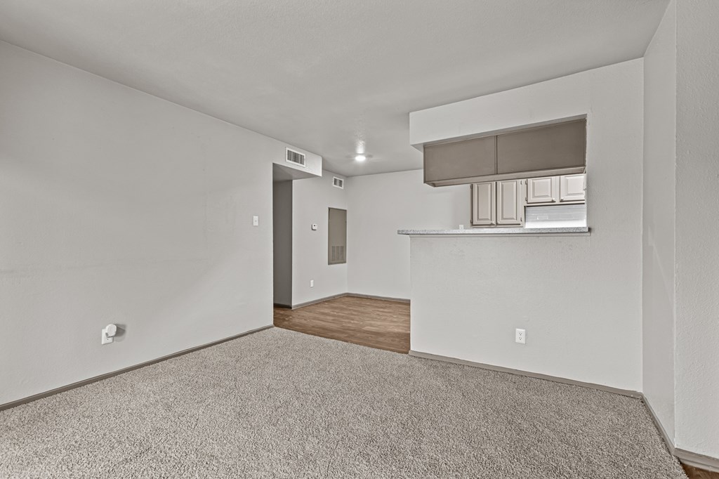 A room with a carpeted floor and a wooden floor in the back.at Rock 35, Round Rock, 78681