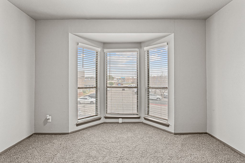 A room with a carpeted floor and a window with blinds.at Rock 35, Texas