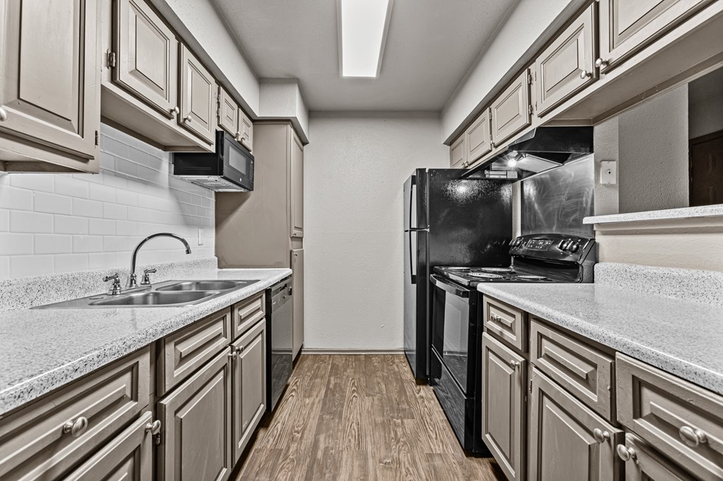 A kitchen with a black refrigerator and a white countertop.at Rock 35, Round Rock, TX, 78681