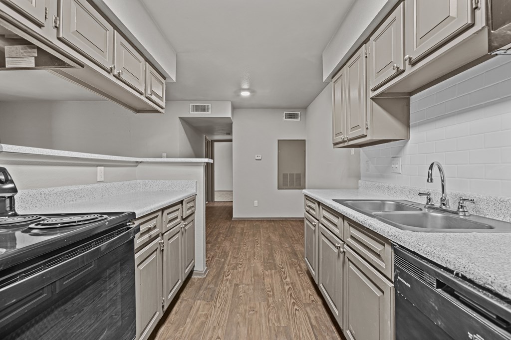 A kitchen with wooden floors and white countertops.at Rock 35, Round Rock, TX