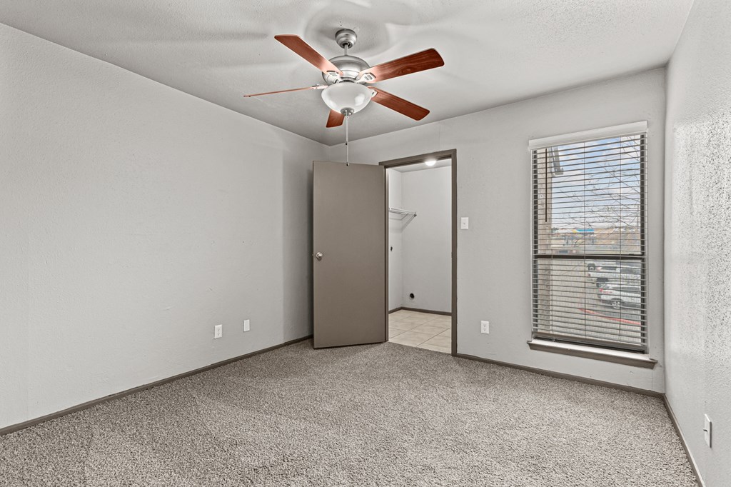 A room with a ceiling fan and a window with blinds.at Rock 35, Round Rock, Texas