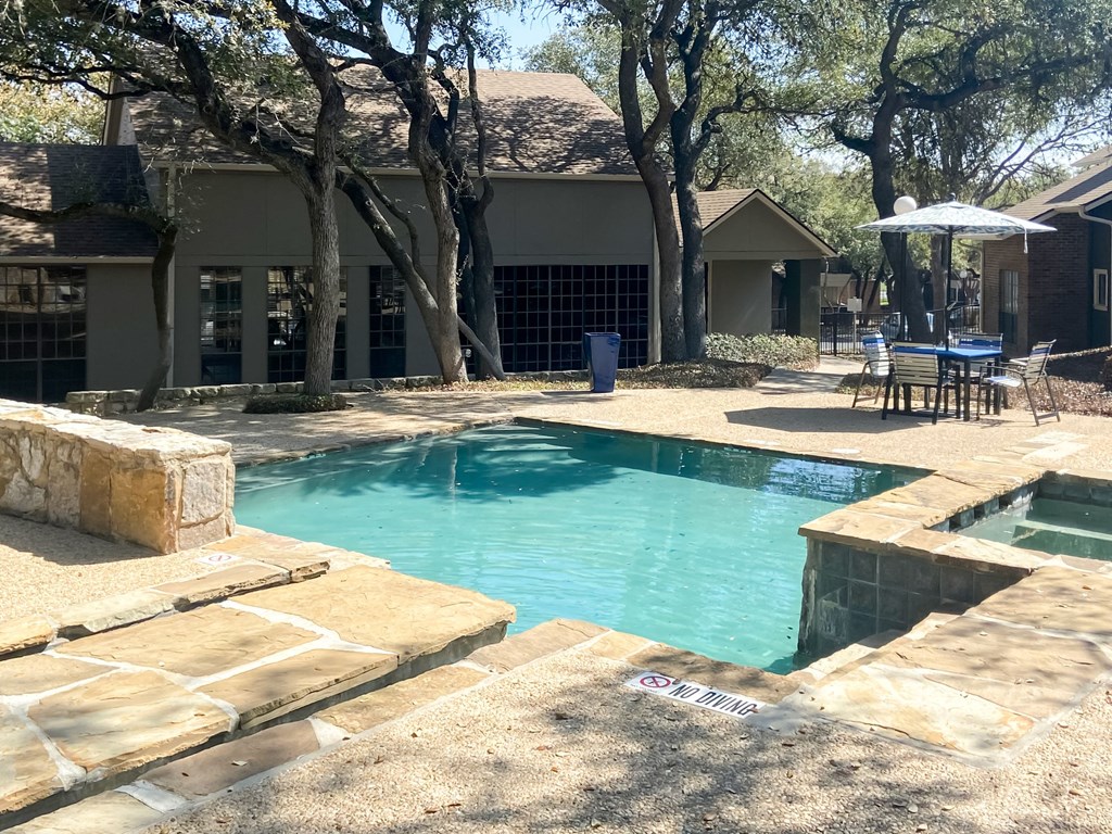 a pool and spa with a house in the background  at Carmel at Deerfield, San Antonio, TX