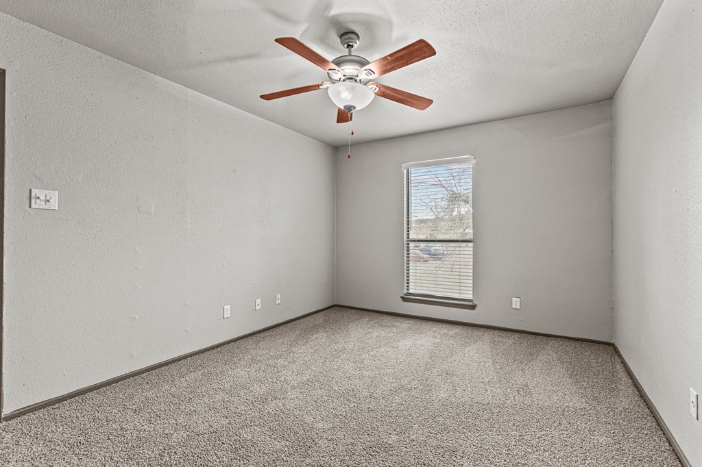 A room with a ceiling fan and a window with blinds.at Rock 35, Round Rock, 78681