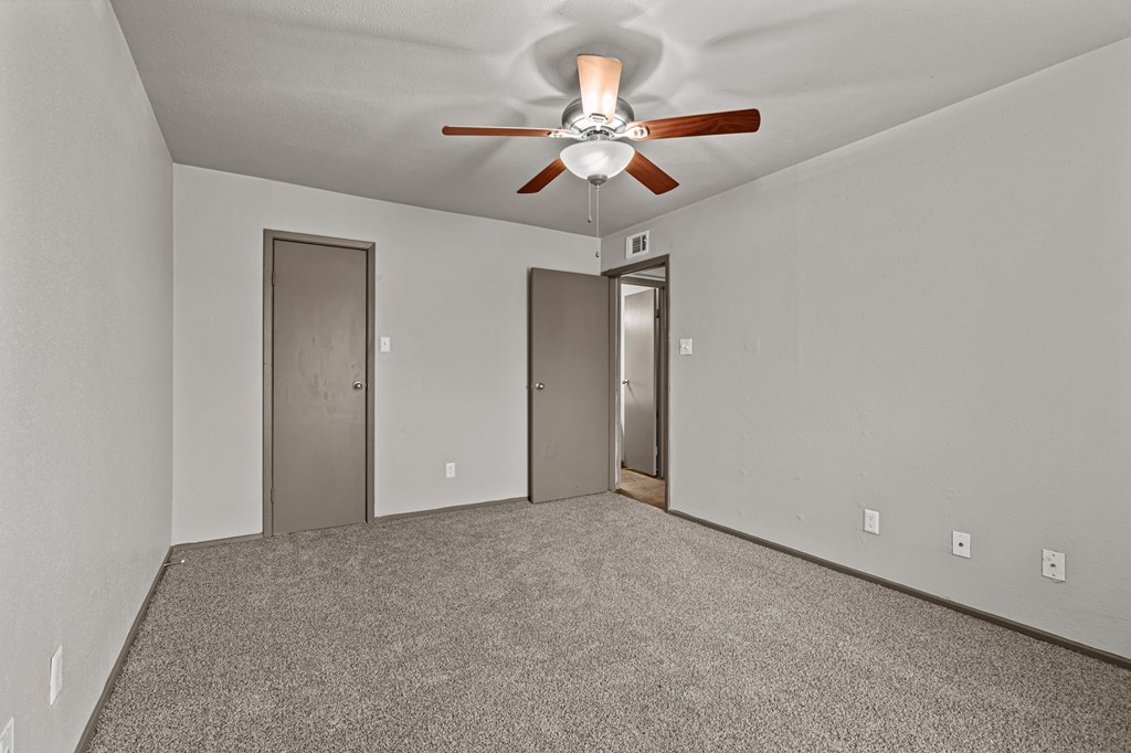 A room with a ceiling fan and two doors.at Rock 35, Round Rock, 78681