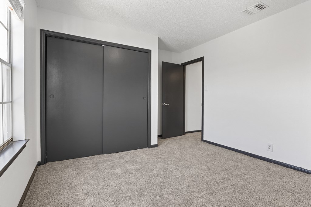 the living room of an apartment with two closets and two doors at Tradewinds, Windcrest, 78239
