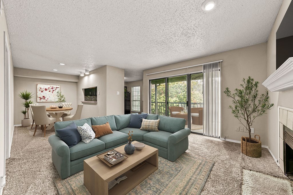 a living room with a blue couch and a coffee table at Legacy Apartments in Plano, TX