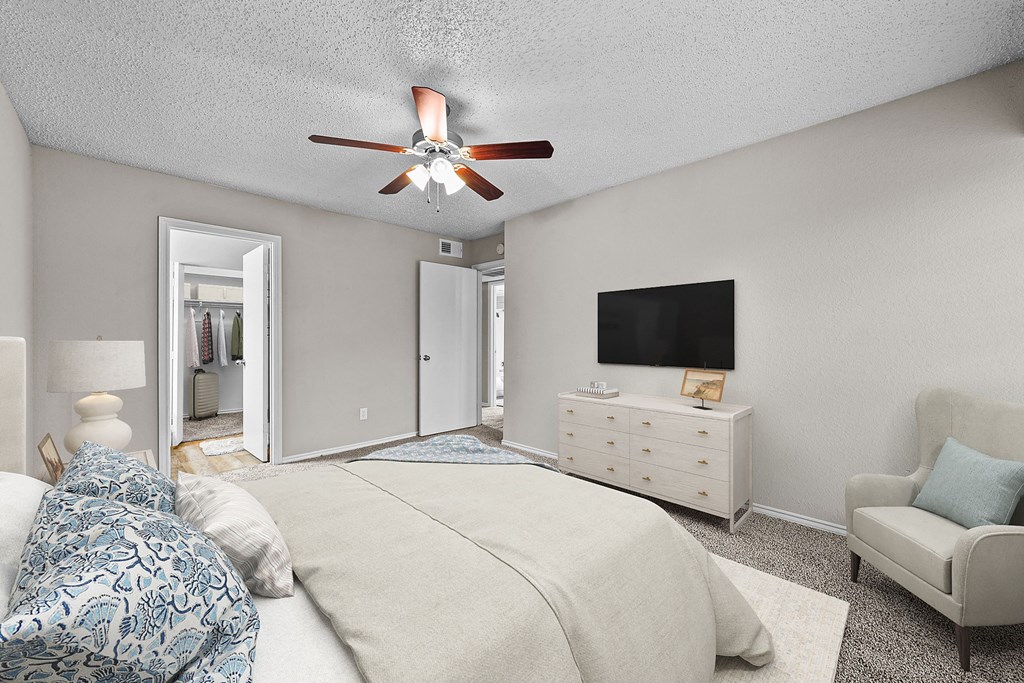 a bedroom with a large bed and a ceiling fan