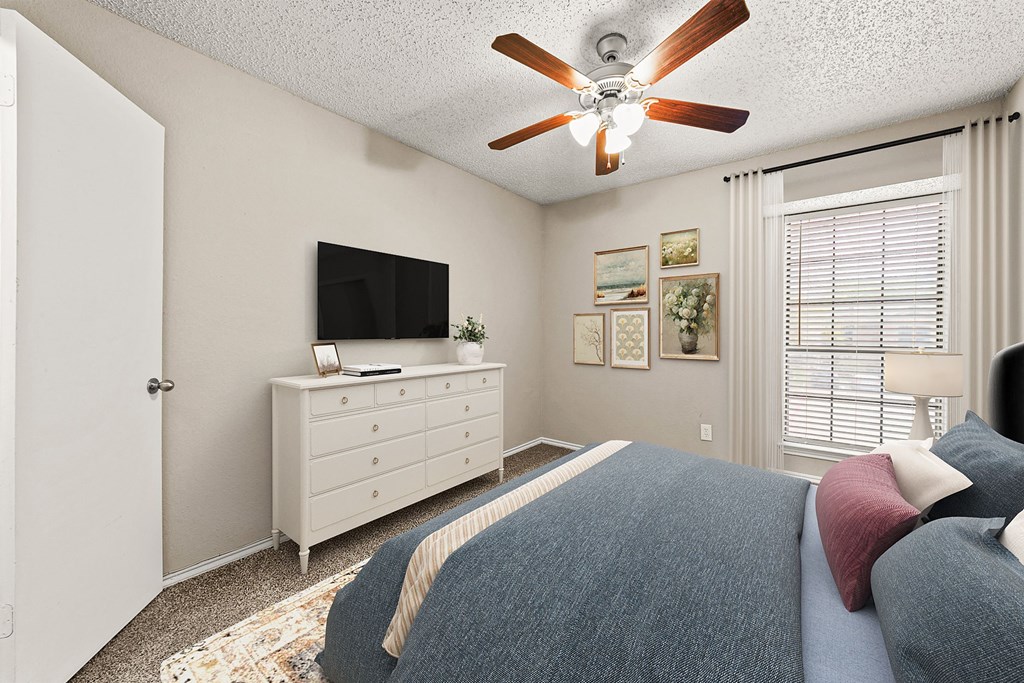 a bedroom with a bed and a ceiling fan