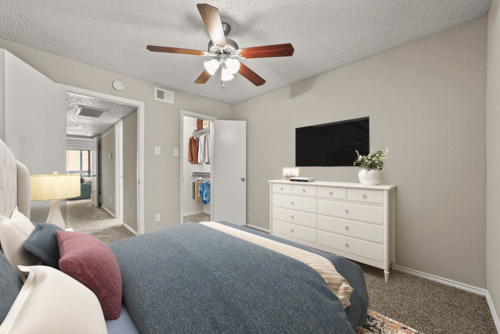 a bedroom with a bed and a ceiling fan