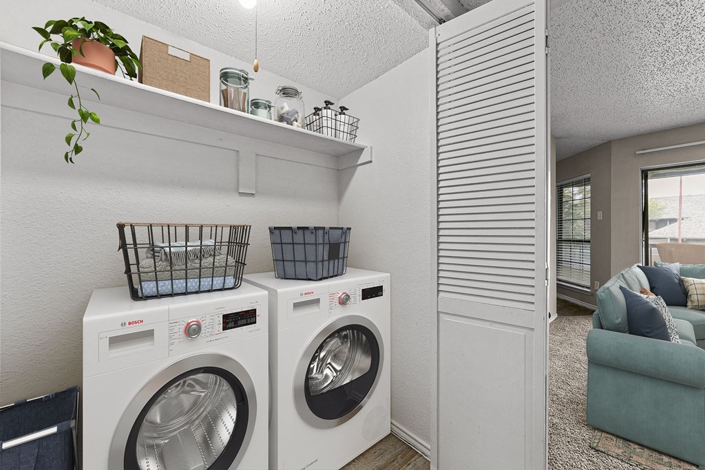 a washer and dryer in a laundry room with a couch