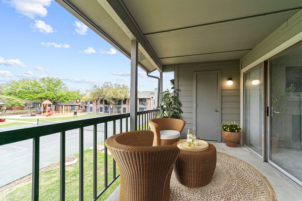 a patio with two chairs and a table on a balcony