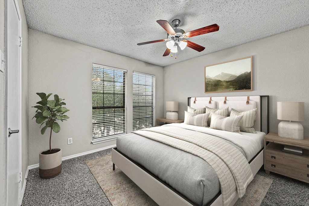 a bedroom with a bed and a ceiling fan a bedroom with a bed and a ceiling fan at Legacy Apartments in Plano, TX
