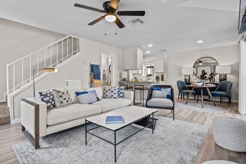 a living room with a couch and a ceiling fan
