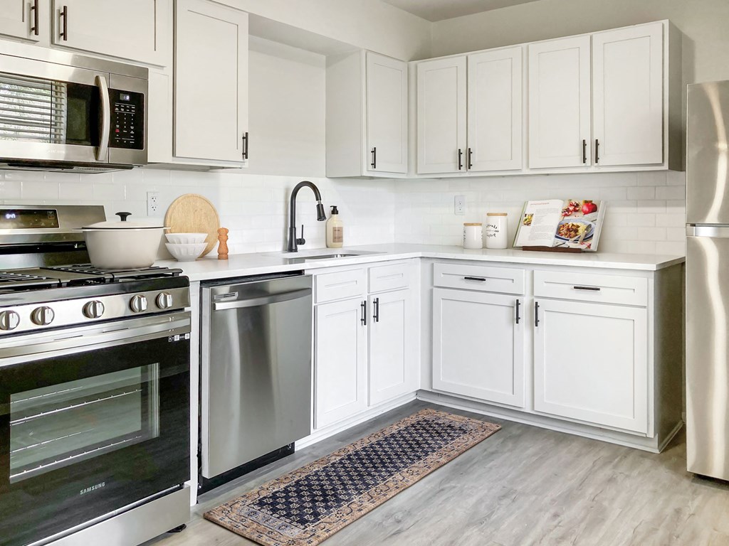 a kitchen with white cabinets and steel appliances at Sunset Heights, San Antonio